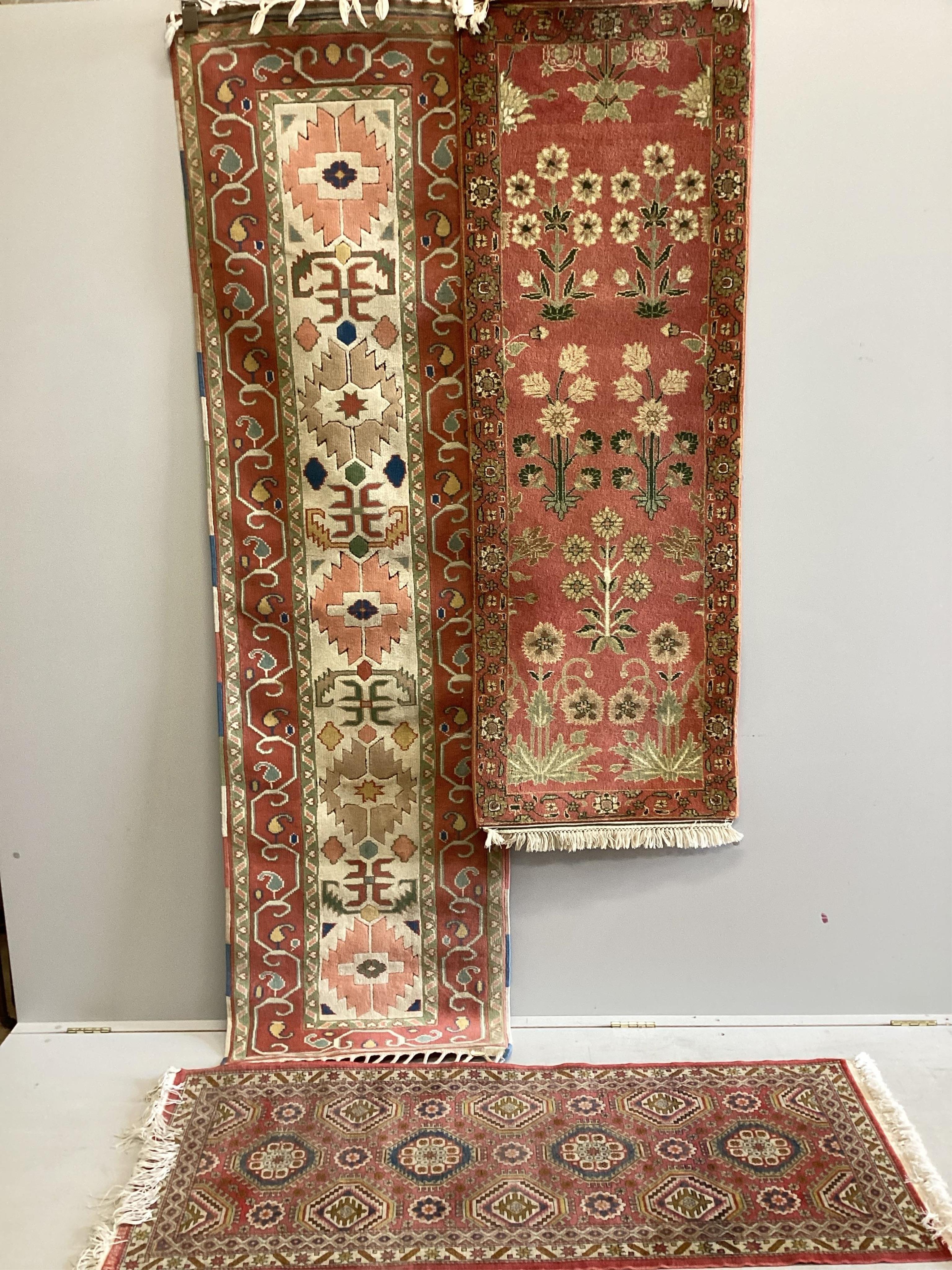 A Caucasian style ivory ground runner and two other red ground runners, largest 248cm x 69cm. Condition - fair